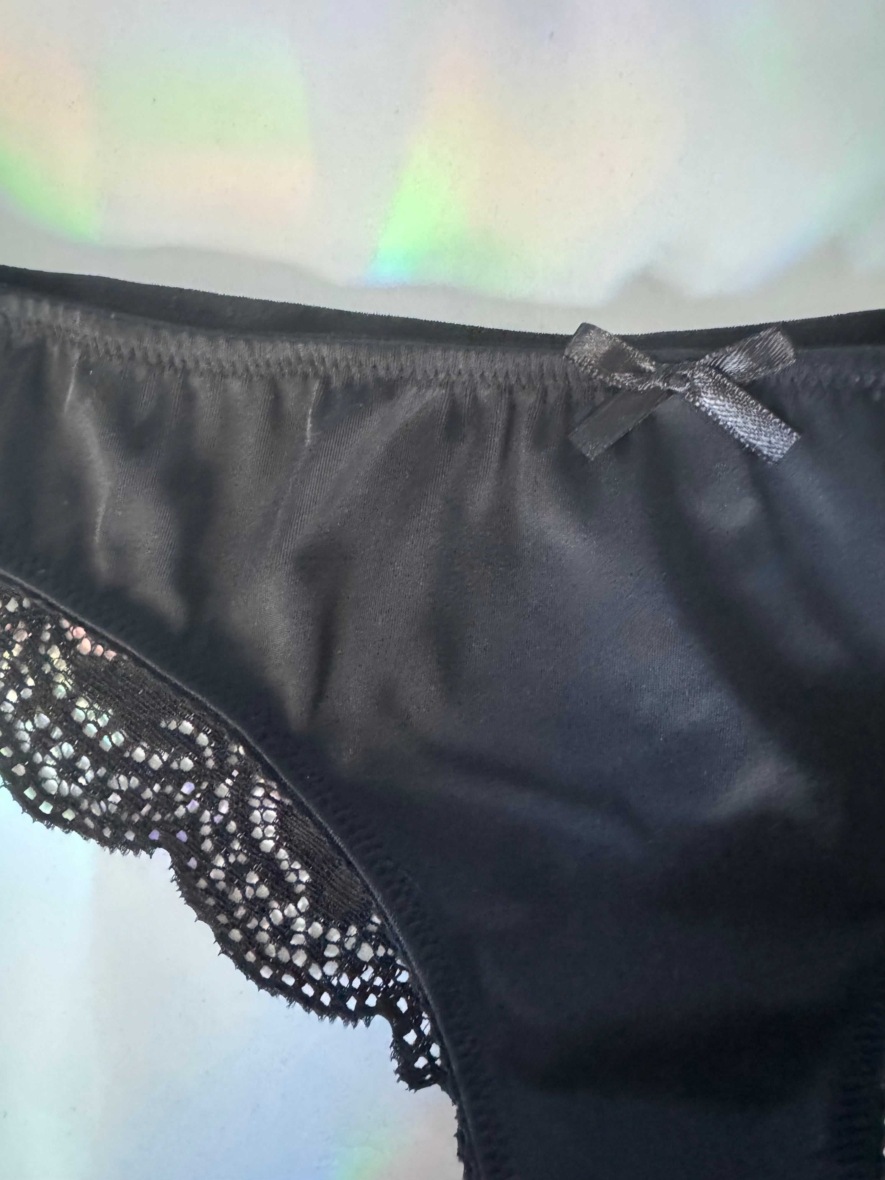 Close up of black brief with lace detail and bow